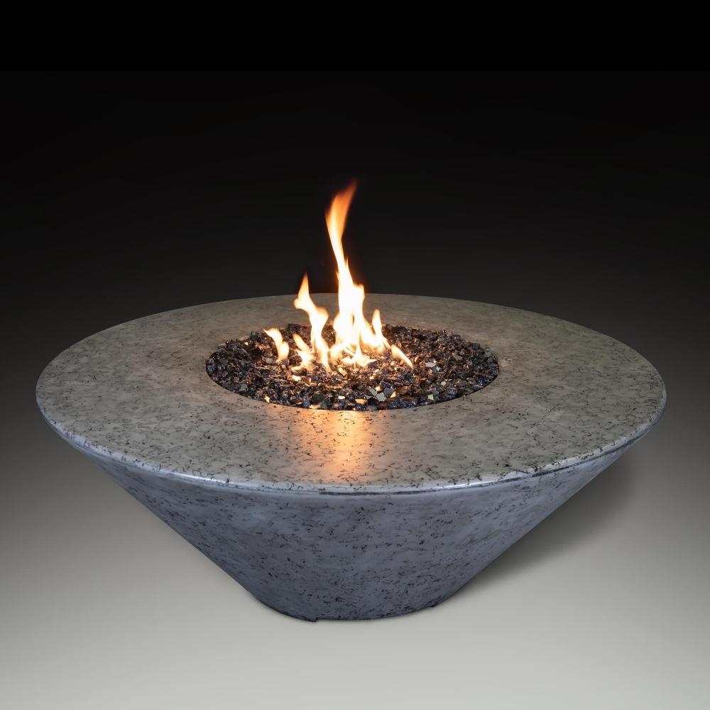 Athena Olympus 44-inch round concrete gas fire pit table with flames and decorative rocks for outdoor gatherings.