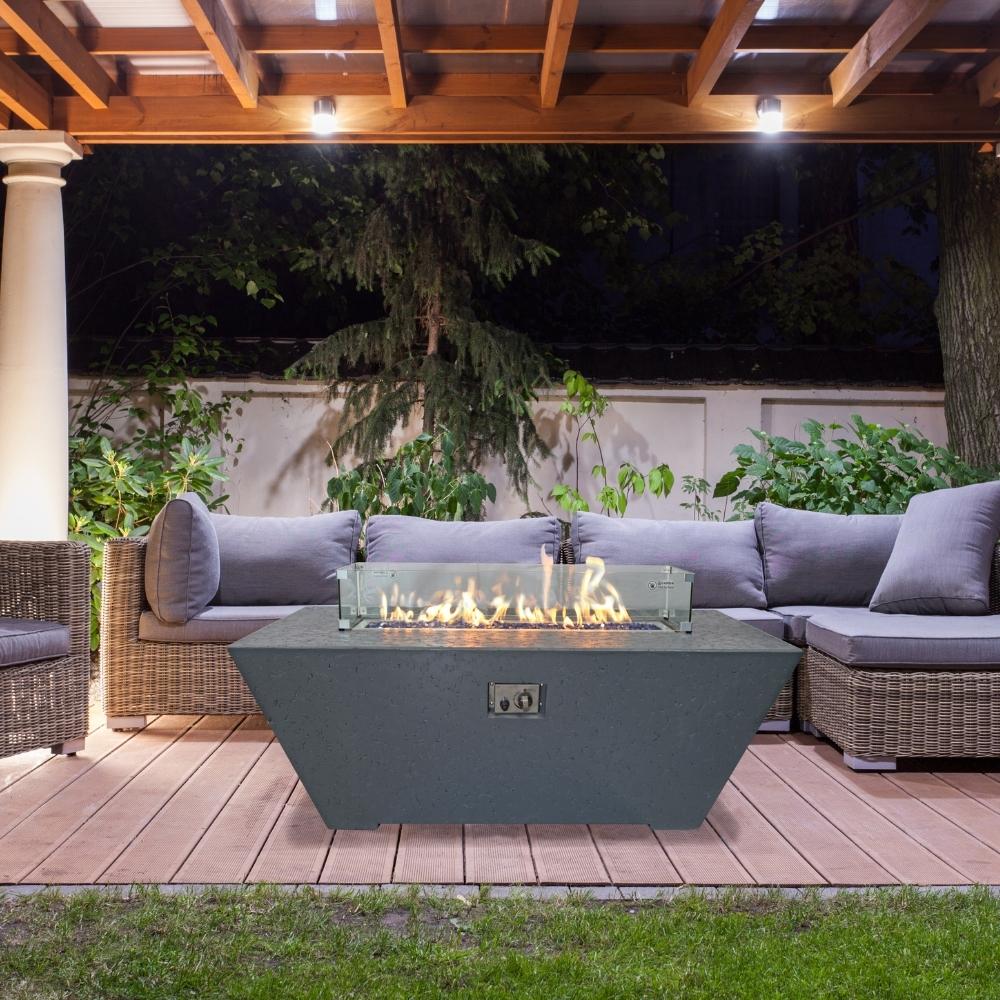 Athena Olympus Rectangular Concrete Gas Fire Pit Table surrounded by outdoor seating on a patio.