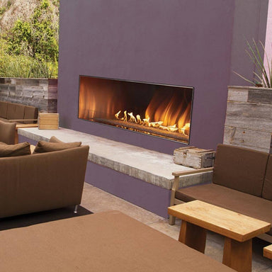Empire Carol Rose Vent-Free Outdoor Linear Gas Fireplace - Modern outdoor living space with a fireplace, couches, and a wooden table.