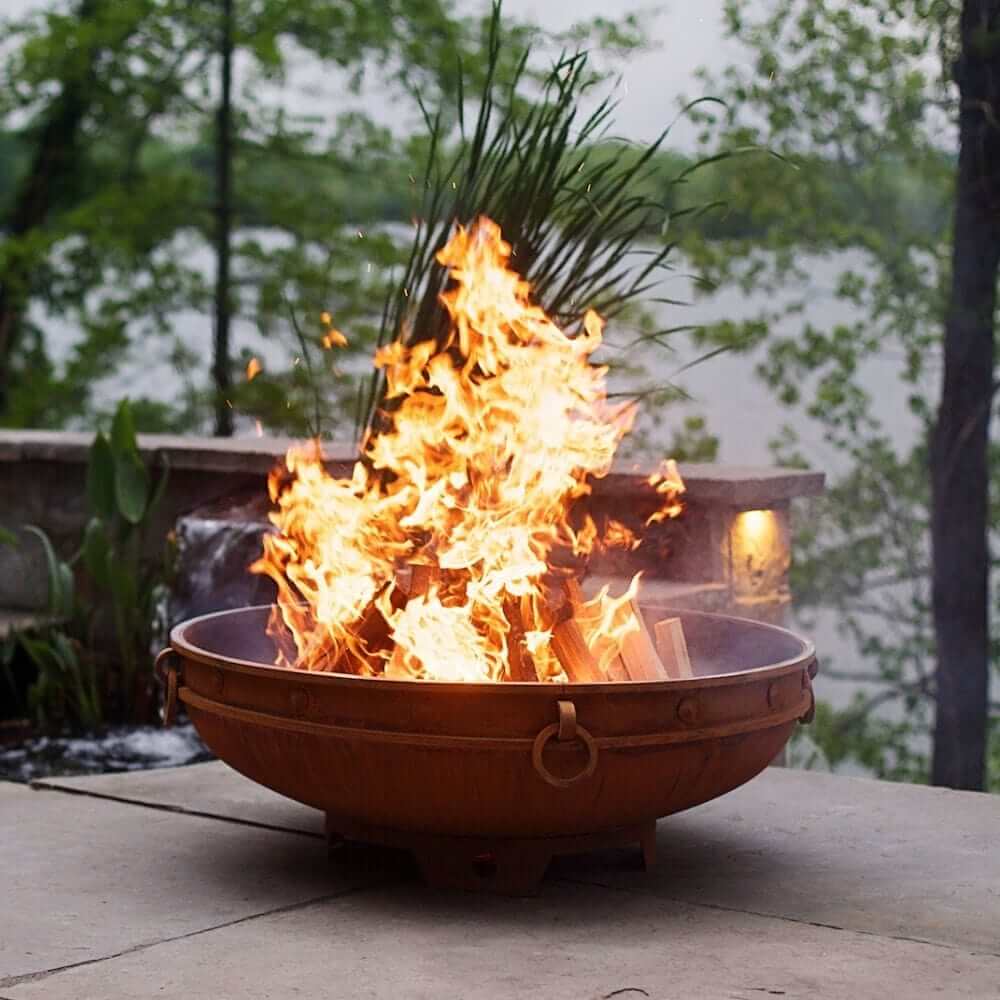 Fire Pit Art Emperor 37-Inch Handcrafted Carbon Steel Fire Pit (EMP) - outdoors next to some greenery