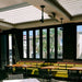 Interior of a modern commercial space with seating, featuring large windows and Bromic electric heater installation.