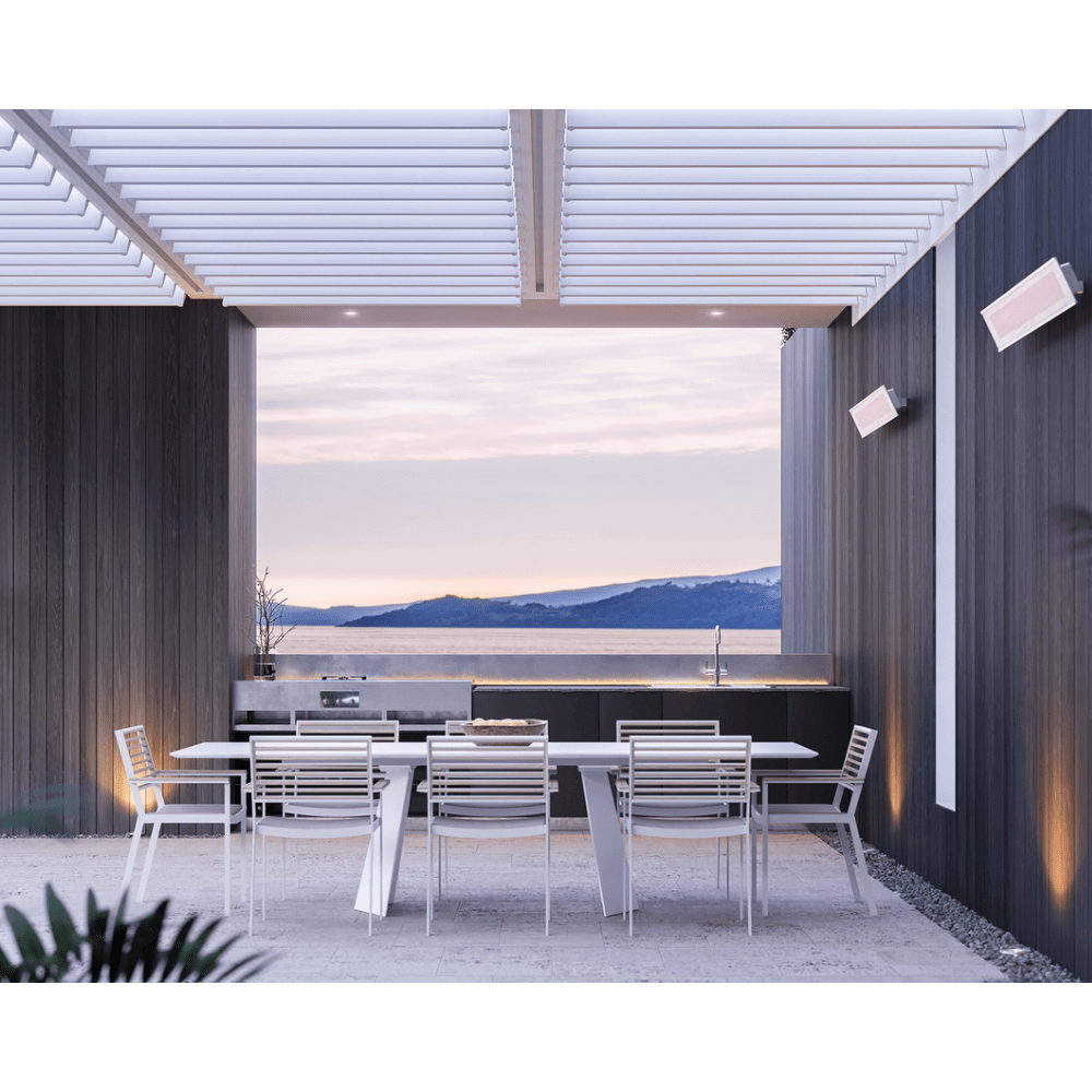Stylish outdoor dining area with Bromic electric heaters, perfect for cold weather gatherings by the water.