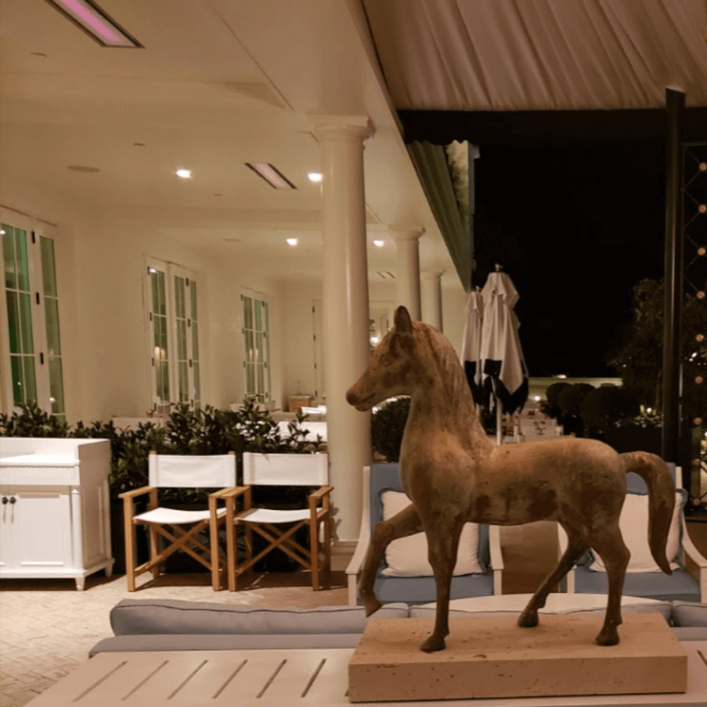Sculpture of a horse in an elegantly designed patio setting at night.
