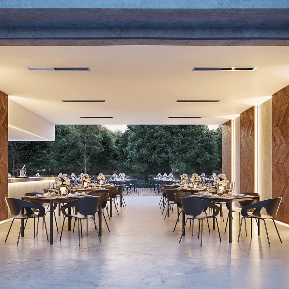 Modern outdoor dining area with elegant tables set for a meal, surrounded by greenery and warm lighting.