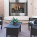 Empire Carol Rose Premium Outdoor Vent Free Gas Fireplace - Outdoor patio with fireplace, chairs, and a table.