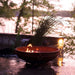 Fire Pit Art Emperor 37-Inch Handcrafted Carbon Steel Gas Fire Pit - next to some plants 