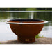 Fire Pit Art Bella Luna 48-Inch Handcrafted Carbon Steel Fire Pit (BL) - Rust-colored fire pit with a white rim on a stone surface by a body of water.