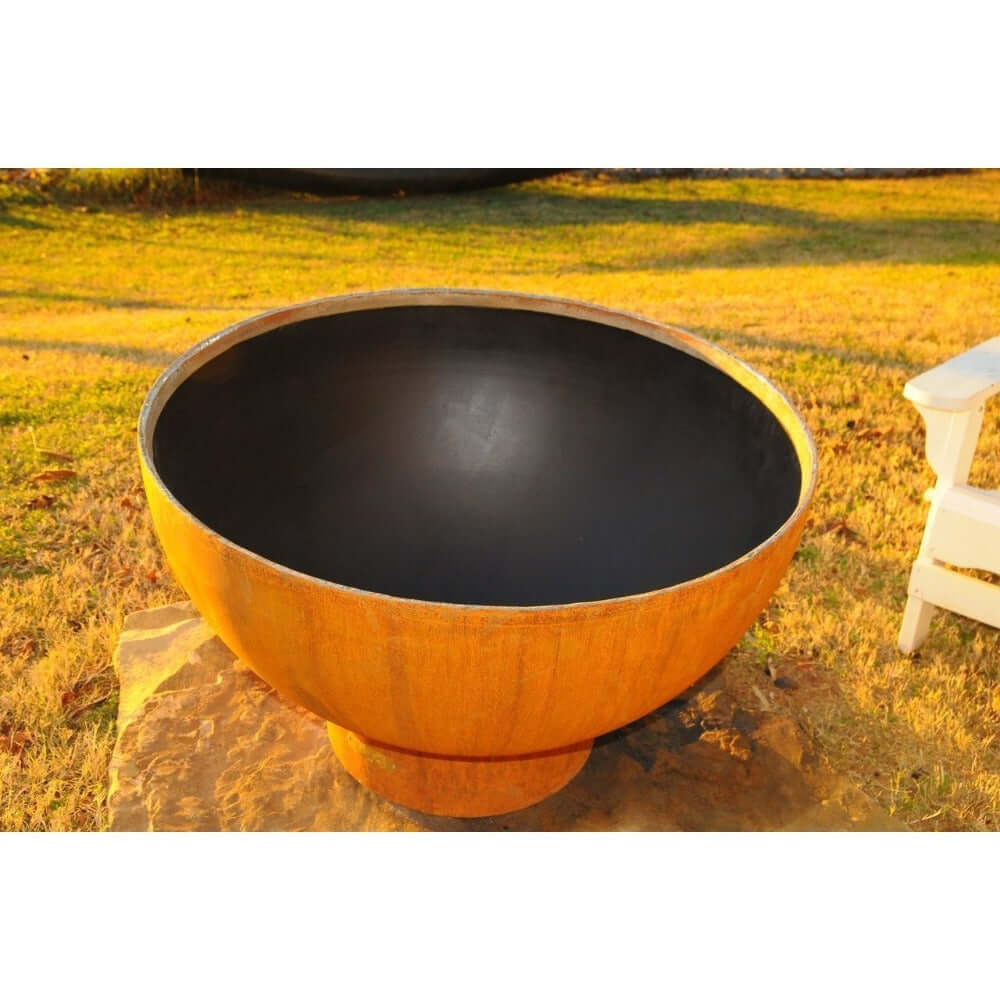 Fire Pit Art Crater 36-Inch Handcrafted Carbon Steel Gas Fire Pit - Large black bowl with a wooden exterior on a grassy field