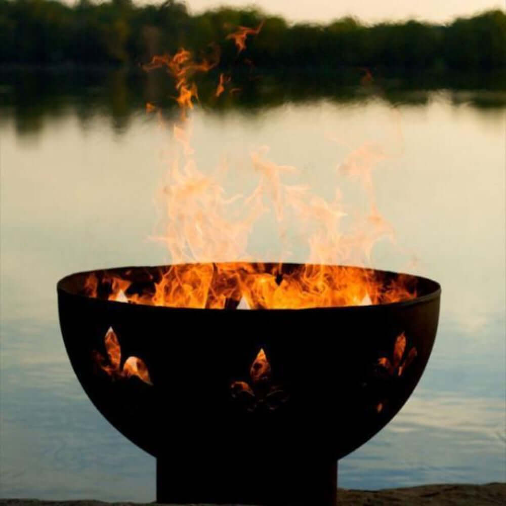 Fire Pit Art Fleur de Lis 36-Inch Handcrafted Carbon Steel Fire Pit (FDL) - Fire pit with flames burning in front of a body of water