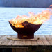 Fire Pit Art Manta Ray 36-Inch Handcrafted Carbon Steel Fire Pit (MR) - Flaming fire pit on a wooden dock by a body of water
