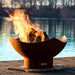 Fire Pit Art Manta Ray 36-Inch Handcrafted Carbon Steel Fire Pit (MR) - Fire pit with flames on a wooden dock by a body of water