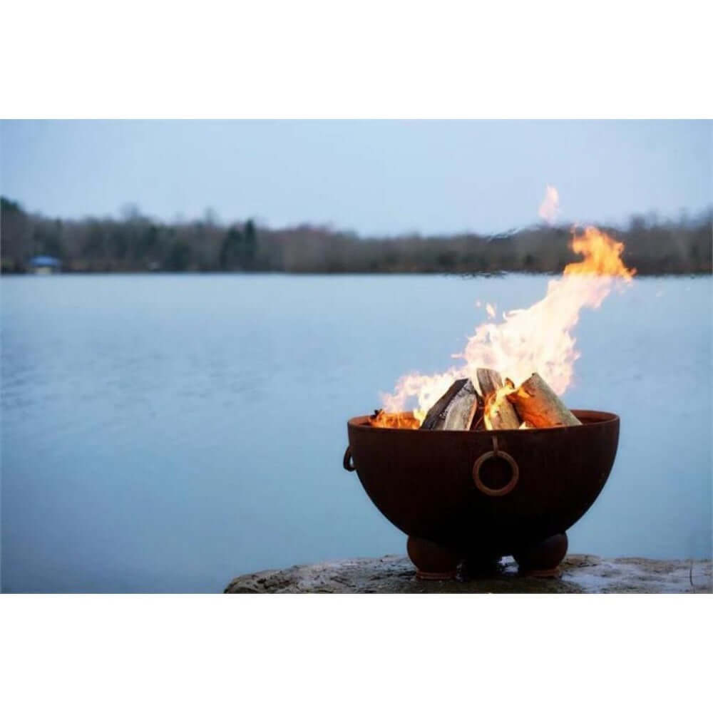 Fire Pit Art Nepal 41-Inch Handcrafted Carbon Steel Fire Pit (NP) - Fire pit with flames burning near a body of water