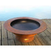 Fire Pit Art Saturn 40-Inch Handcrafted Carbon Steel Fire Pit (SAT) - Rust-colored fire pit on a wooden deck with a blurred water background