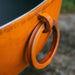 Fire Pit Art Nepal 41-Inch Handcrafted Carbon Steel Gas Fire Pit - Close-up of a brown leather handle on an orange object with a blurred background