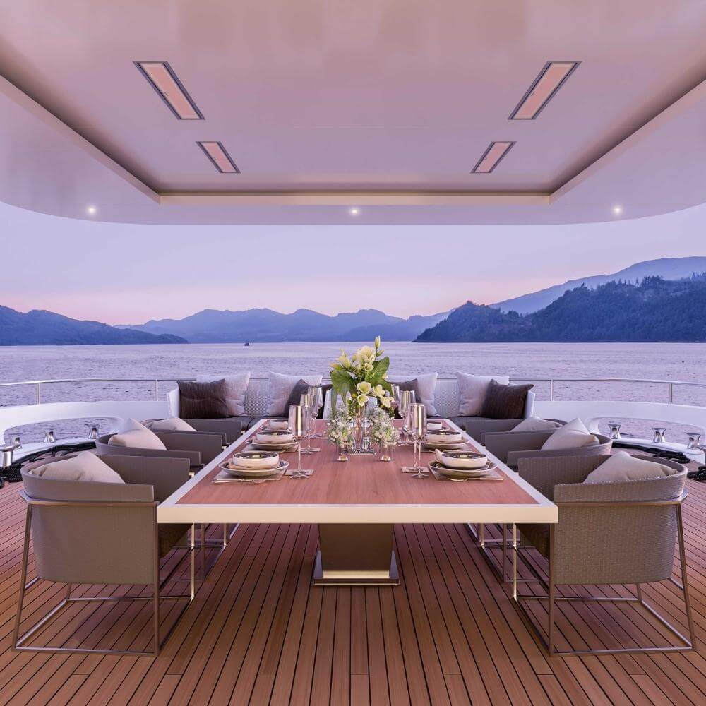 Elegant outdoor dining area with a view, featuring a stylish table, chairs, and sunset backdrop over the water.