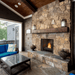 Outdoor stone gas fireplace with a wooden mantle and cozy seating area for entertaining.
