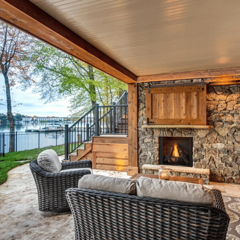 Cozy outdoor space featuring a natural gas fireplace and comfortable seating by the lake.