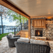 Cozy outdoor space featuring a natural gas fireplace and comfortable seating by the lake.