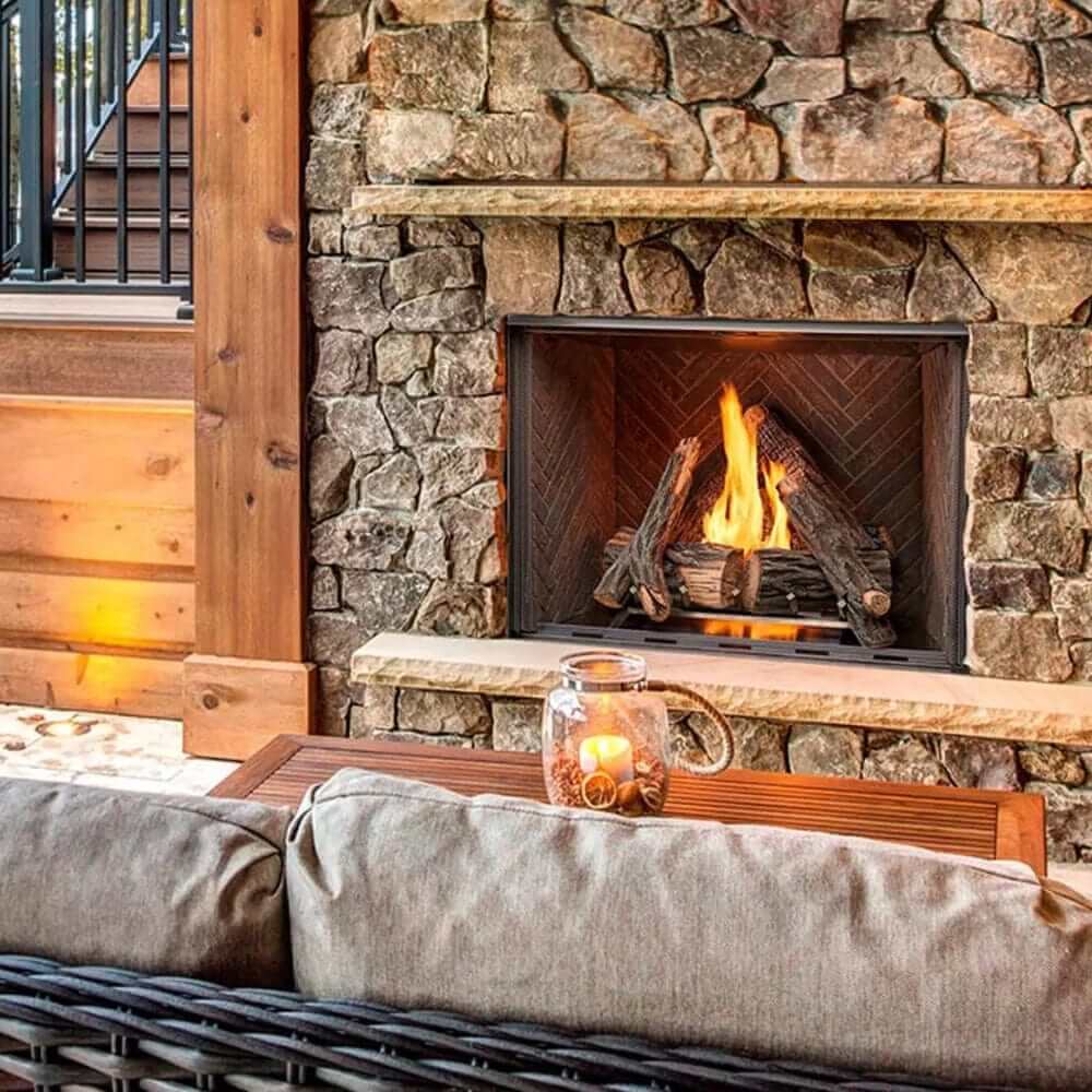 Cozy vent-free outdoor gas fireplace with natural stone surround and glowing flames.