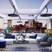 Modern living room featuring Bromic Eclipse heaters, city skyline view, stylish decor and furniture.