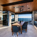 Modern dining area with a wooden table and sea views, showcasing a stylish outdoor space.