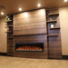 Allwood Fireplace Wall System for Spectrum Slimline Electric Fireplace - A modern wall-mounted electric fireplace with realistic flames, surrounded by dark wood shelves and soft warm lighting.