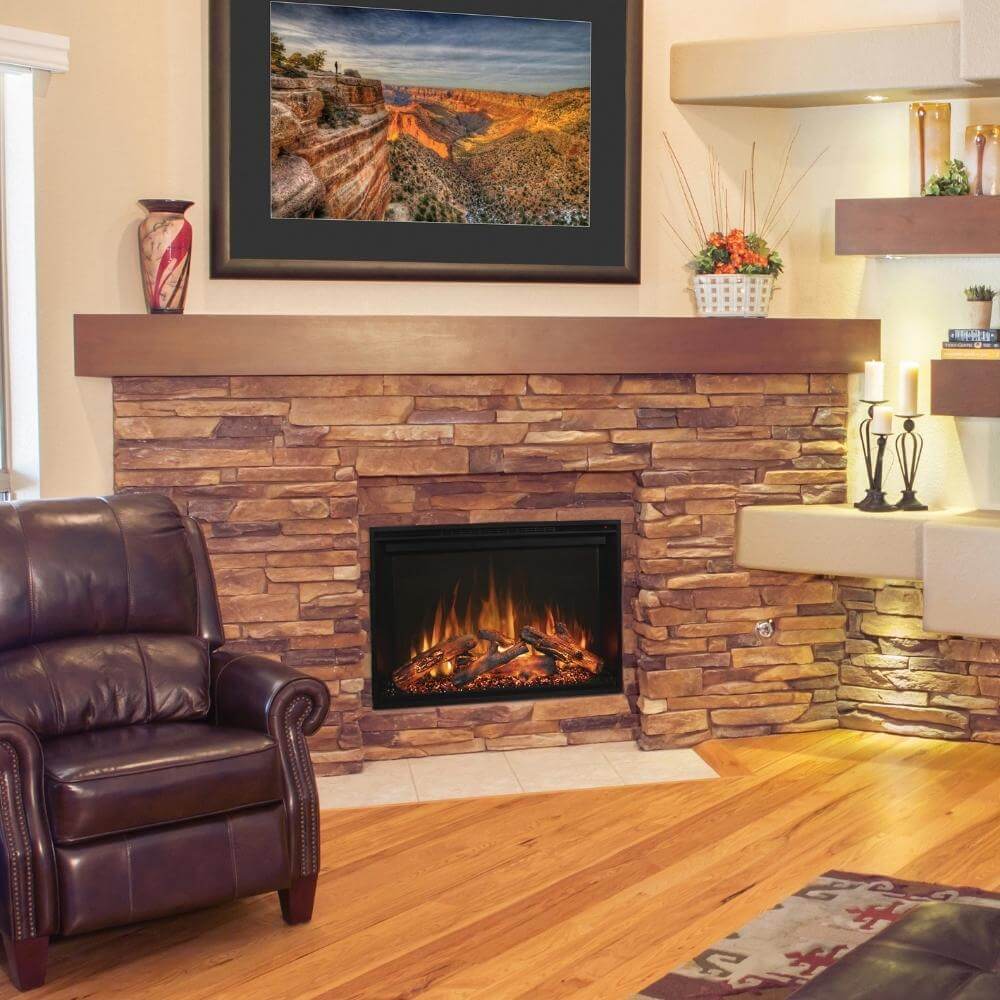 Redstone 26" Built-in Electric Fireplace Insert - Cozy living room featuring a leather armchair, stone fireplace with flames, and a scenic landscape painting above the mantel.