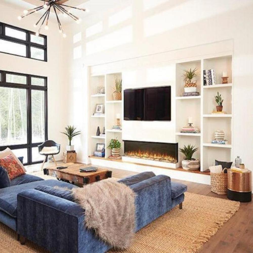 Stylish living room featuring a blue sectional sofa, modern decor, and a sleek built-in electric fireplace.