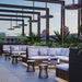 Stylish outdoor seating area featuring modern design with Bromic Eclipse Smart-Heat ceiling heaters and lush greenery.