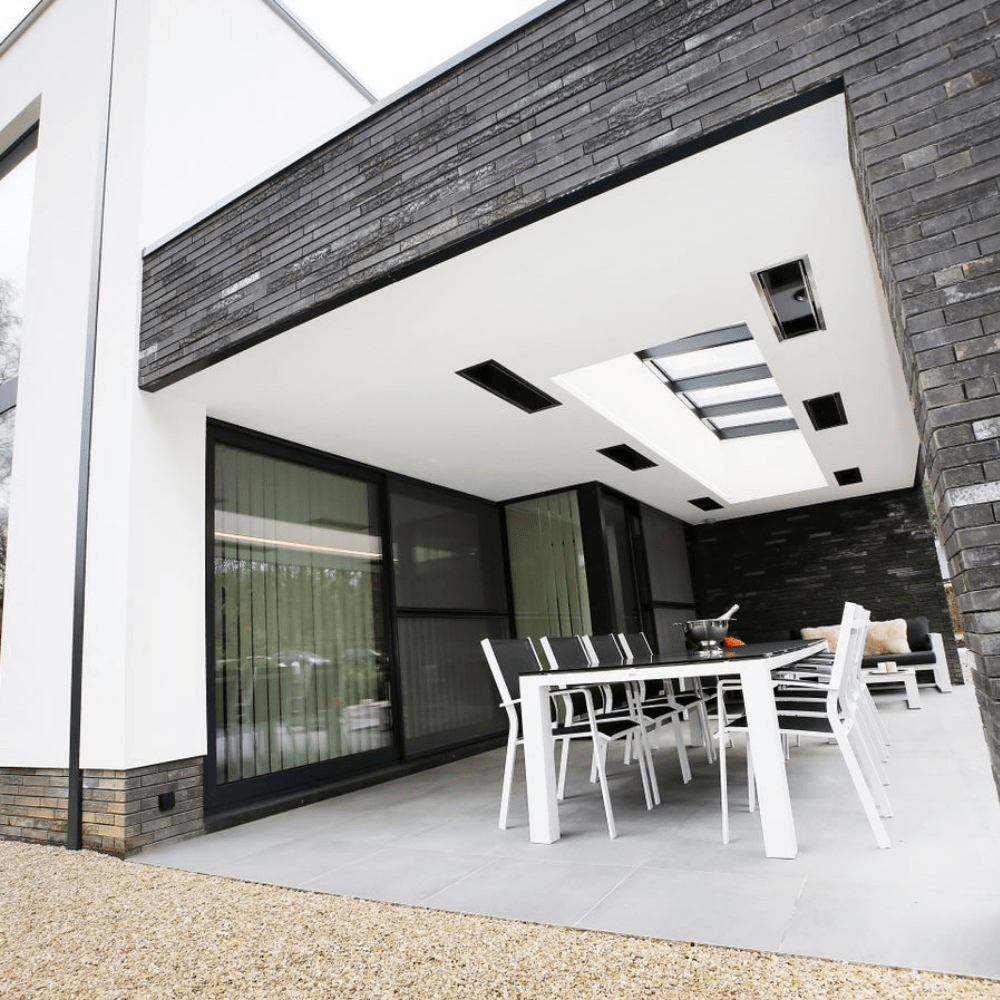 Modern outdoor patio with minimalist design and sleek dining area featuring a Bromic heater for warmth.