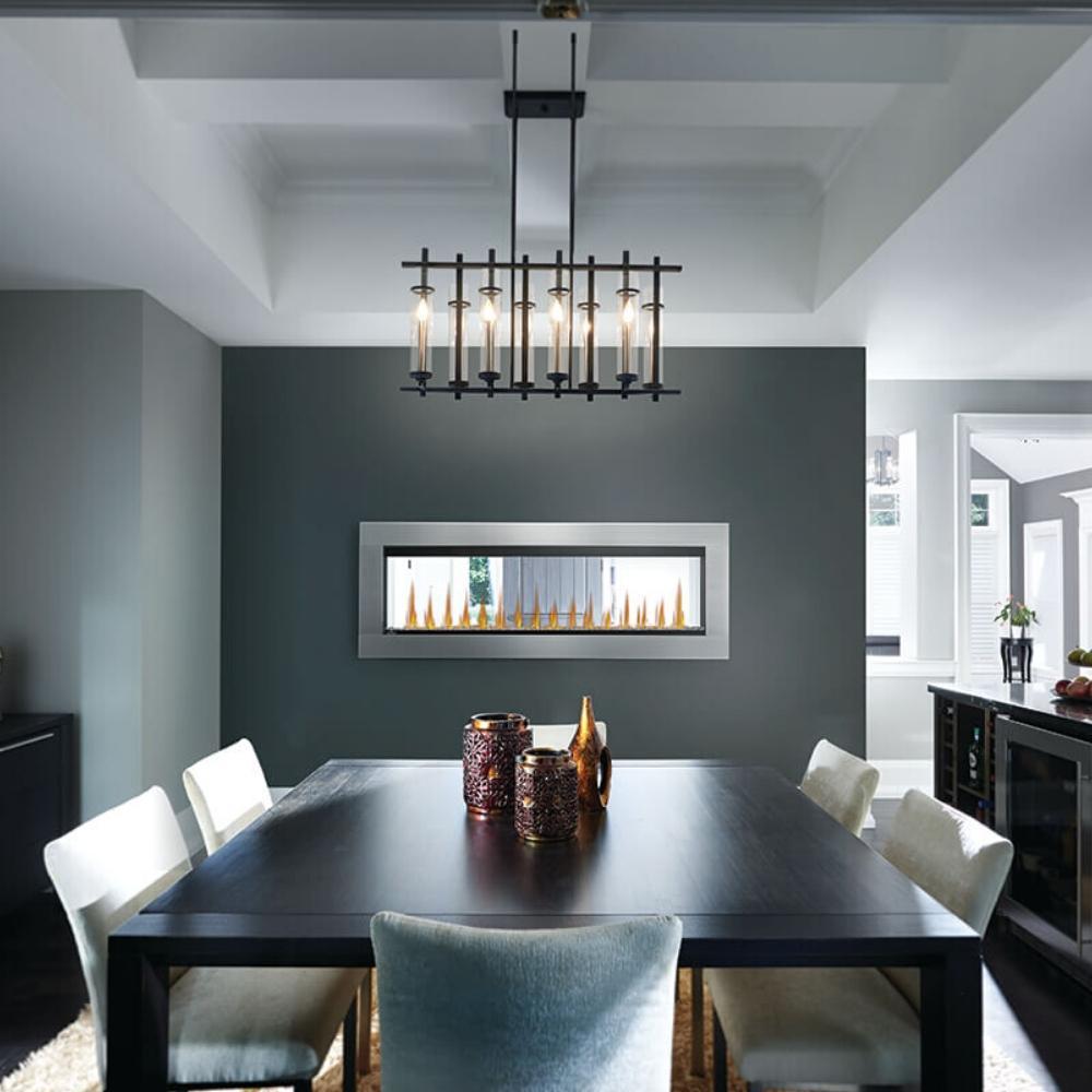 Modern dining room with a black table, white chairs, and a two-sided electric fireplace for ambiance.