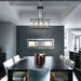 Modern dining room with a black table, white chairs, and a two-sided electric fireplace for ambiance.