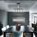 Modern dining room featuring a sleek table, stylish chairs, and a two-sided electric fireplace.
