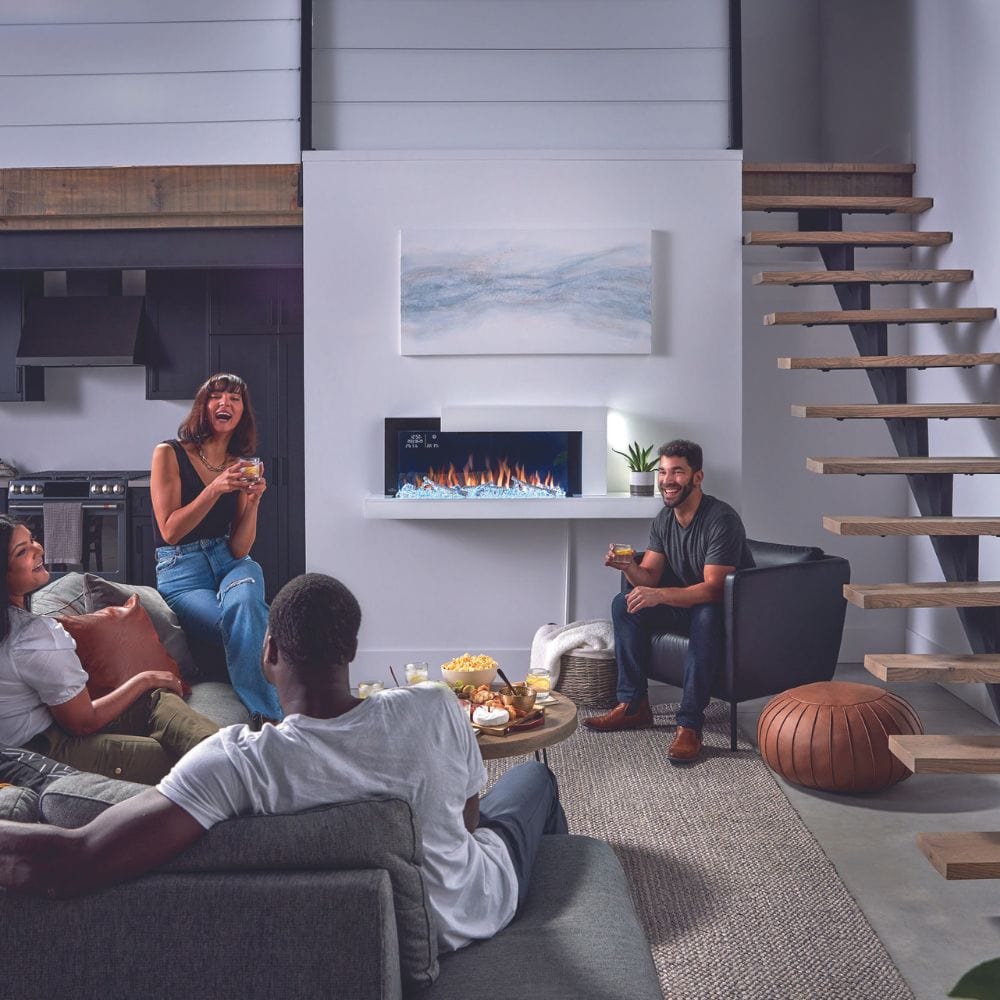 Cozy gathering with friends around a Napoleon Stylus Cara Elite electric fireplace in a modern living room.