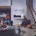 Cozy gathering with friends around a Napoleon Stylus Cara Elite electric fireplace in a modern living room.