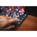 Close-up of hand using touch controls on Napoleon Stylus electric fireplace with glowing crystals.