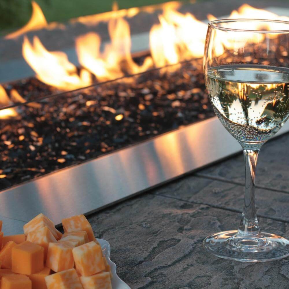 Empire Carol Rose Outdoor Stainless Steel Linear Gas Burner - Glass of white wine and cheese cubes by a fire pit