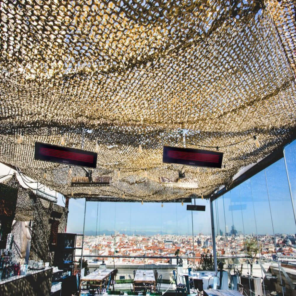 Stylish outdoor terrace with Bromic electric heaters and a canopy, offering warmth and stunning city views.