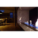 The Bio Flame 38-Inch Ethanol Fireplace Burner, Indoor/Outdoor - A vibrant fireplace blazes with flames, while a table stands in the background