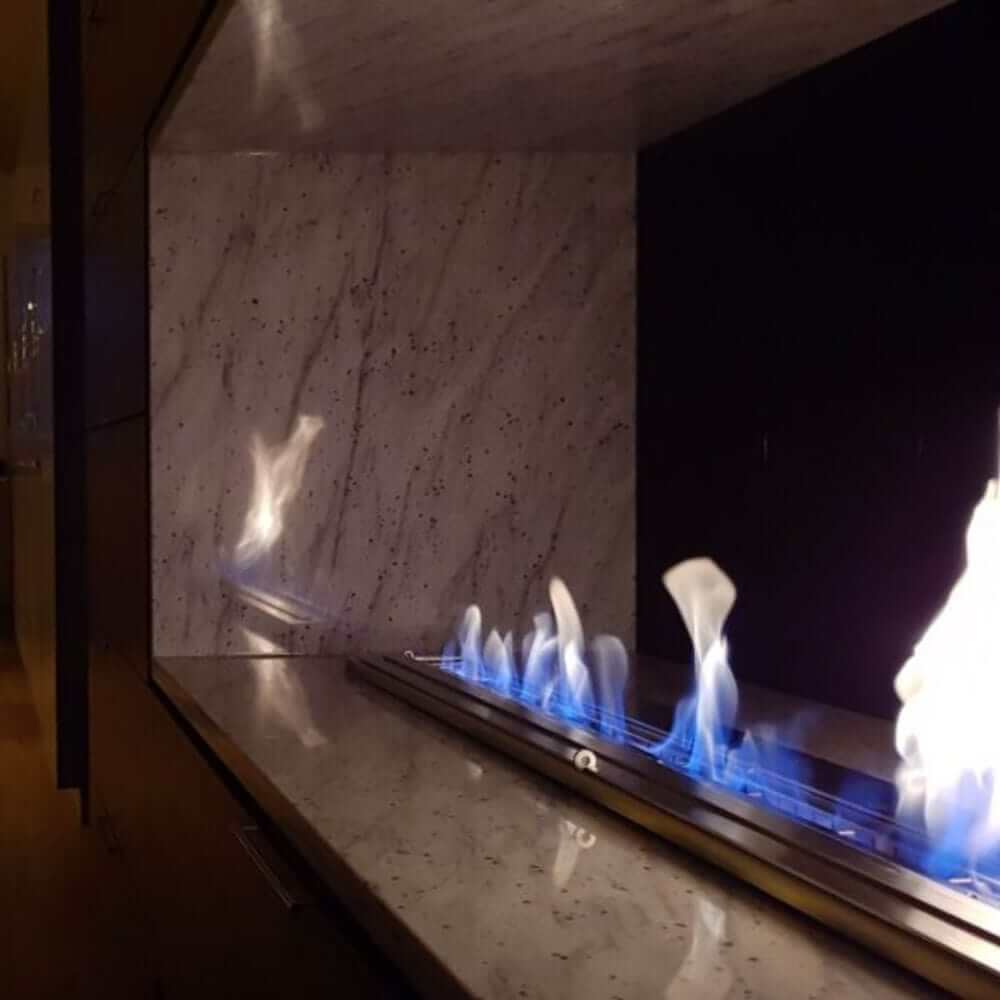 The Bio Flame 38-Inch Ethanol Fireplace Burner, Indoor/Outdoor - A modern living space showcasing a fireplace with mesmerizing blue flames