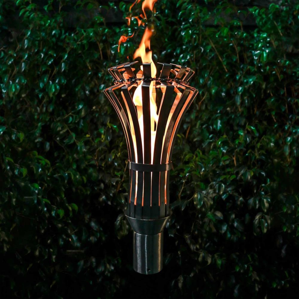 Outdoor Plus 14-Inch Gothic Stainless Steel Gas Torch - next to a greenery