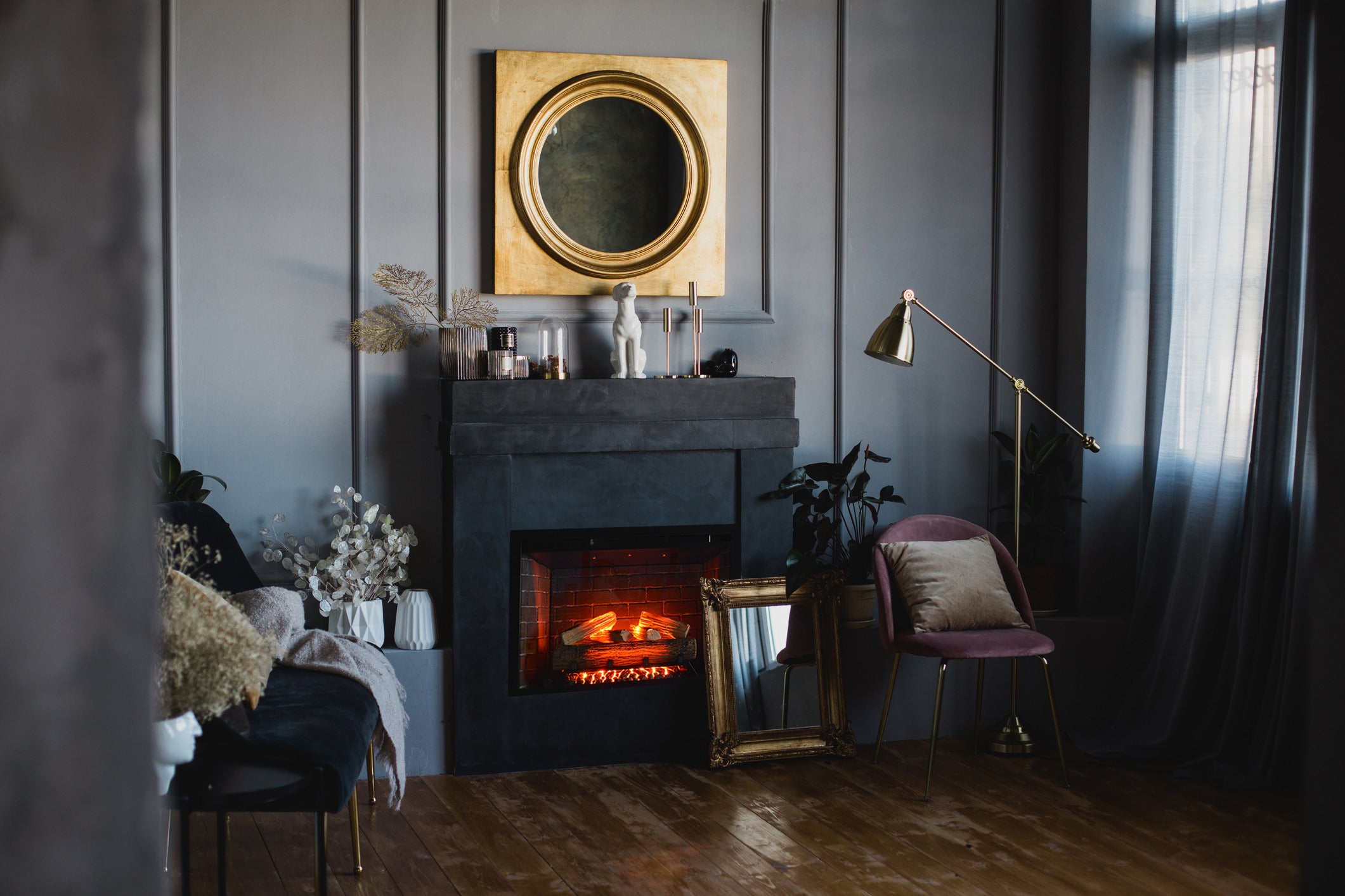 Classic Edition Electric Fireplace by Fire & Ice - Cozy living room with a fireplace, decorative mirror, and soft lighting.